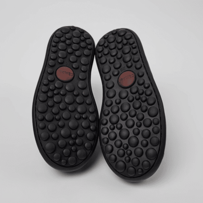 Pendientes de calzado negro con suela antideslizante y patrón de burbujas, ideales para comodidad y estilo en Zapaterías Luis Rico.