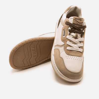Zapatillas deportivas de color beige y blanco con suela antideslizante para hombres y mujeres, ideales para estilo casual y comodidad en tiendas de calzado Luis Rico.