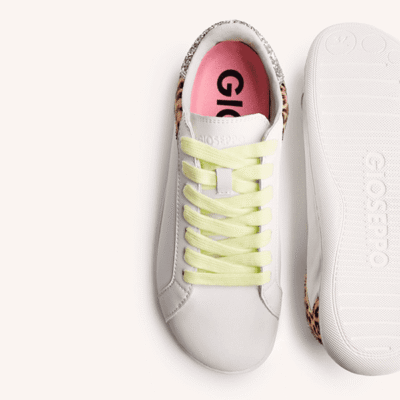 Zapatos deportivos blancos con suela de goma y detalles en animal print en los laterales, ideales para un estilo casual y cómodo.