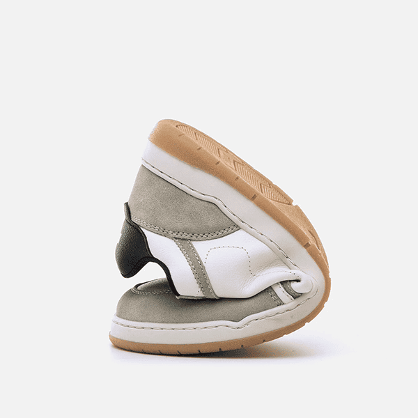 Botas de calzado infantil flexibles y antideslizantes para niños en tonos beige, gris, blanco y negro, ideales para comodidad y seguridad.