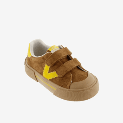 Zapatillas deportivas infantiles de color marrón con detalles en amarillo, con cierre de velcro, ideales para niños y confort en calzado de calidad.