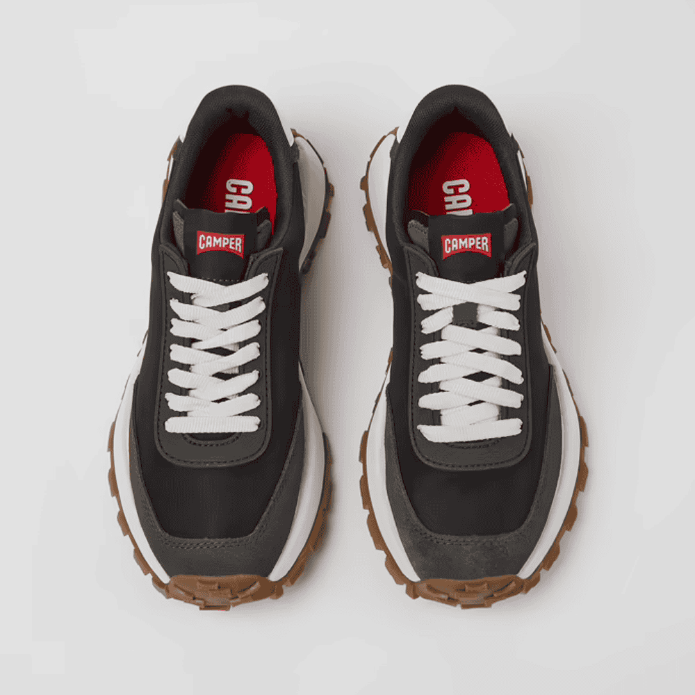 Zapatillas deportivas casuales de marca Camper en color negro con detalles en blanco y suela de goma resistente, ideales para estilo urbano y comodidad diaria.