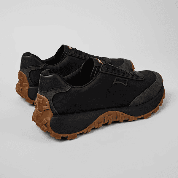 Zapatos deportivos de senderismo en color negro con suela antideslizante en tono marrón, ideales para actividades outdoor y trekking. Diseñados por Tiendas de Calzado Luis Rico para comodidad y resistencia.