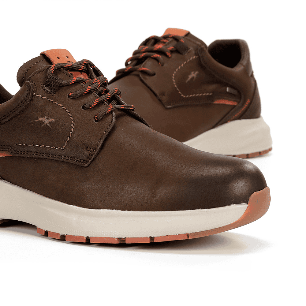 Zapatillas de deporte casual en color marrón con suela blanca y detalles en naranja, ideales para comodidad y estilo en tienda de calzado Luis Rico.
