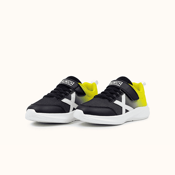 Zapatillas deportivas infantiles de diseño moderno, en color negro con detalles en amarillo y blanco, ideales para niños activos y en movimiento en tiendas de calzado Luis Rico.