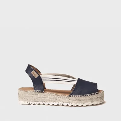 Las sandalias planas mujer cómodas Toni Pons en color azul marino están diseñadas para ofrecer una opción versátil y funcional para los meses de verano. Este modelo combina diseño mediterráneo y comodidad, adaptándose a diferentes estilos sin esfuerzo. El color azul marino aporta una estética elegante y fácil de combinar, convirtiendo estas sandalias en un básico imprescindible. Este tipo de sandalias planas mujer cómodas es ideal para quienes buscan un calzado práctico para el uso diario. La cuña de esparto de 4 cm aporta una altura ligera sin perder estabilidad, lo que permite utilizarlas durante toda la jornada con comodidad. Esto las convierte en una opción muy práctica para el verano. Fabricadas en piel, ofrecen una buena adaptación al pie y una mayor durabilidad. Además, las tiras elásticas permiten un ajuste sencillo, facilitando el calce y aportando sujeción. La plantilla acolchada mejora la sensación en la pisada, permitiendo un uso prolongado sin molestias. Estas sandalias están pensadas para acompañarte en diferentes momentos del día. Estas sandalias Toni Pons mujer destacan por su versatilidad, siendo una opción perfecta para combinar con vestidos, conjuntos veraniegos o looks más casuales. Puedes descubrir más modelos similares en nuestra tienda online: https://luisrico.es Toni Pons es una marca reconocida por su calzado de esparto y su estilo mediterráneo. Puedes conocer más sobre sus colecciones en su web oficial: https://www.tonipons.com En resumen, estas sandalias planas mujer cómodas son una opción versátil para el verano, pensadas para quienes buscan un calzado práctico, elegante y adaptado al uso diario.