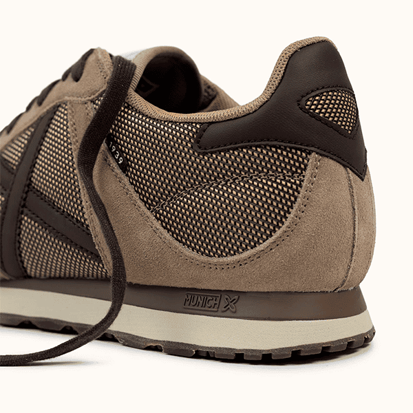 Zapatos deportivos de hombre en tonos beige y negro, con diseño transpirable y suela antideslizante, ideales para correr y actividades al aire libre en tiendas de calzado Luis Rico.