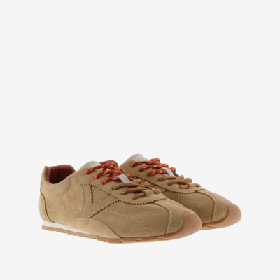 Zapatos de hombre deportivos en color beige con detalles en marrón y cordones naranjas, ideales para outfit casual y urbano.