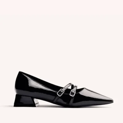 Tacón de mujer elegante en zapatos de charol negro con doble hebilla, perfecto para tendencia y comodidad.